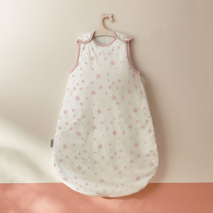 Silentnight Safe Nights Stars Baby Sleep Bag with pink stars hung on a white wall